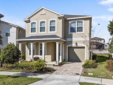 Two-story house with a neutral color scheme, a large garage, and a well-manicured lawn at 1808 Sandy Park Trl, Kissimmee, FL 34747