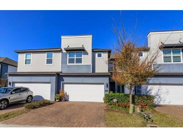 Modern two-story townhome with two-car garage and landscaped front yard at 2229 Shadowland Loop, Winter Park, FL 32792
