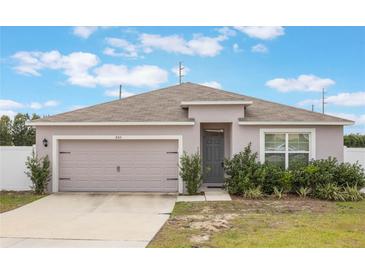 One-story house with attached garage and landscaping at 845 Colville Dr, Poinciana, FL 34759