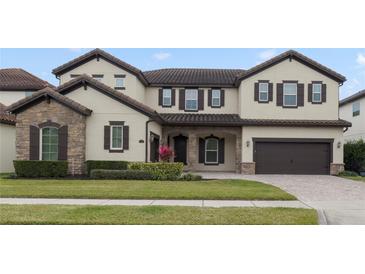 Two-story house with stone accents and a three-car garage at 11769 Hampstead St, Windermere, FL 34786