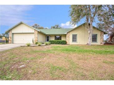 Ranch style home with a green roof, attached garage, and a spacious yard at 1220 Alden Ter, Deltona, FL 32738