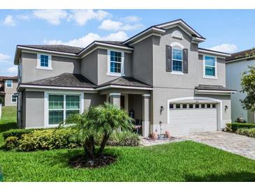 Two-story house with gray siding, three-car garage, and landscaping at 1873 Donahue Dr, Ocoee, FL 34761