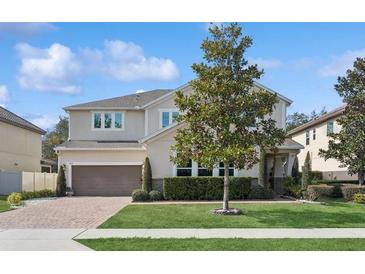 Two-story house with a large front yard, brick driveway and a three-car garage at 284 Tuska Reserve Cv, Casselberry, FL 32707