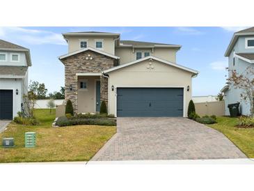 Two-story house with stone accents and a gray garage door at 4398 Davos Dr, Clermont, FL 34711