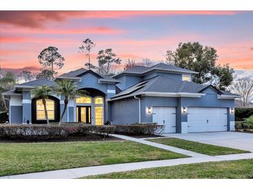 Stunning two-story home with a three-car garage and manicured lawn at 5590 Whispering Woods Pt, Sanford, FL 32771