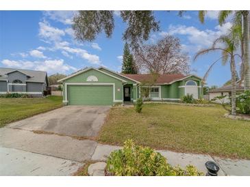 Green house with a two-car garage and well-maintained lawn at 926 Freshmeadow Ct, Apopka, FL 32703