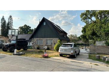 A-frame home with solar panels, a basketball hoop, and a spacious yard at 1911 Geigel Ave, Orlando, FL 32806