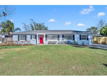 Charming ranch home with red door, brick facade, and spacious lawn at 2127 Lake Dr, Winter Park, FL 32789