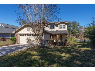 Two-story house with beige exterior, brick accents, and a two-car garage at 3511 Exeter Ct, Orlando, FL 32812