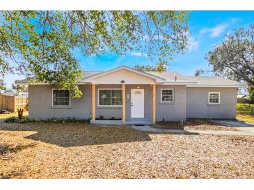 Newly renovated gray brick home with a white door and wood posts at 355 E Hoffman St, Lake Alfred, FL 33850