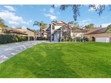 Two-story house with a paved driveway and manicured lawn at 3886 Lake Mirage Blvd, Orlando, FL 32817