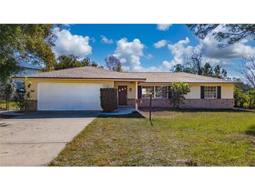 Ranch-style home with a white garage door and well-manicured lawn at 501 S Lacy Cir, Deltona, FL 32725