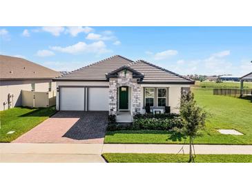 One-story home with two-car garage, brick paver driveway, and landscaped yard at 5157 Citrus Leaf Blvd, Winter Garden, FL 34787