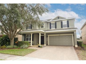 Two-story house with a gray exterior, a brick driveway, and landscaping at 528 Legacy Park Dr, Casselberry, FL 32707