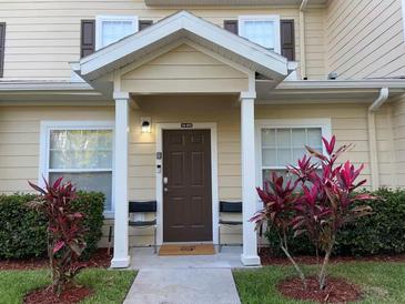 Inviting exterior with covered entryway, landscaping, and two chairs at 5352 Diplomat Ct # 103, Kissimmee, FL 34746