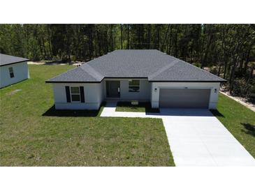 Charming single-story home with a two-car garage and pristine landscaping at 13188 Sw Sw 65Th Cir, Ocala, FL 34473