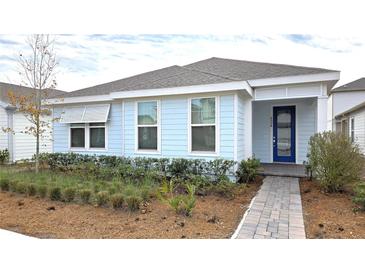Light blue house with a blue door and landscaping at 6554 Rover Way, St Cloud, FL 34771