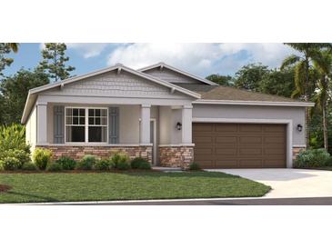 One-story home with gray siding, brown garage door, and stone accents at 12795 Trovita Dr, Grand Island, FL 32735