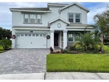 Two-story house with gray siding, white garage door, and landscaped lawn at 1445 Olympic Club Blvd, Champions Gate, FL 33896