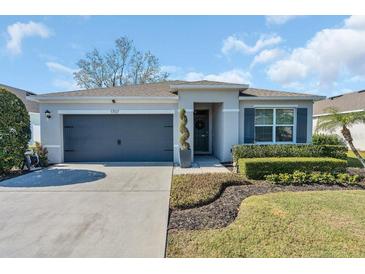 Two-story house with gray siding, landscaping, and a two-car garage at 1707 Point O Woods Ct, Mount Dora, FL 32757