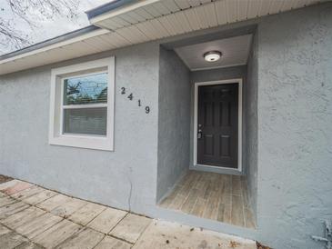 Newly renovated house exterior, featuring a gray facade and a modern front door at 2419 Rio Pinar Lakes Blvd, Orlando, FL 32822