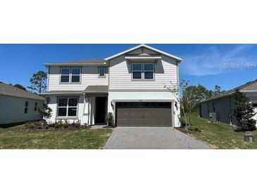 Charming two-story home features a gray exterior, well-maintained lawn, and a two-car garage at 5425 Log Grove Ln, Orlando, FL 32829