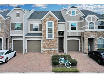 Two-story townhome with stone accents and a two-car garage at 558 S Terrace Spring Dr, Orlando, FL 32828