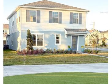 Two-story house with light blue and white siding, landscaping, and a driveway at 10876 Waterwood Aly, Orlando, FL 32829