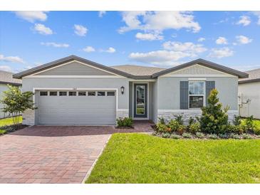 Gray house with a two-car garage and a landscaped front yard at 1365 Hanoverian Dr, Lake Alfred, FL 33850