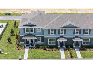 Two-story townhouses with gray roofs and landscaping at 2785 Flushing Dr, Apopka, FL 32703