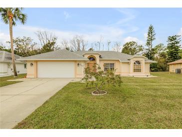 House exterior featuring a one-story home with a front yard and attached garage at 4572 Woodcove Dr, Port Orange, FL 32127