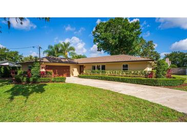 Charming single-story home with well-manicured lawn and mature landscaping under a blue sky at 4914 Gran Lac Ave, Belle Isle, FL 32812