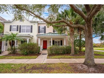Inviting exterior of charming townhome with red door and lush landscaping at 8773 Silk Bay Pl, Orlando, FL 32827