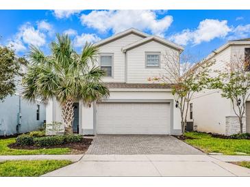 Two-story house with gray siding, gray garage door, and palm trees at 8906 Zurich Ln, Kissimmee, FL 34747