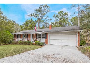 Brick ranch house with carport, front porch, and mature landscaping at 15941 Sw 8Th Pl, Ocala, FL 34481