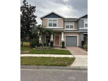 Two-story townhome with attached garage and front landscaping at 16307 Old Ash Loop, Orlando, FL 32828