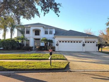 Two-story home with three-car garage and manicured lawn at 2177 Cascades Cove Dr, Orlando, FL 32820