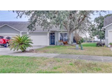 House exterior featuring a well-maintained lawn, driveway, and landscaping at 654 Harbor Villa Ct, Clermont, FL 34711