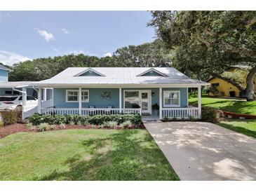 Quaint light blue house with a front porch and lush green lawn at 801 E 8Th Ave, New Smyrna Beach, FL 32169