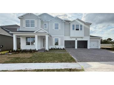 Two-story home featuring a light gray exterior, a brick paved driveway, and an attached two-car garage at 2726 Ravencliffe Ter, Oviedo, FL 32765