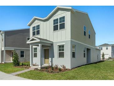 Two-story house with gray and beige siding, landscaping, and a paved walkway at 368 Belmond Dr, Debary, FL 32713