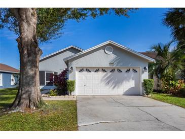 Gray house with white garage door, landscaping, and driveway at 1511 Oak Hill Trl, Kissimmee, FL 34747