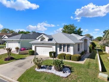 Charming single-story home featuring a two-car garage, mature landscaping, and a well-maintained lawn at 5024 St Andrews Arc, Leesburg, FL 34748