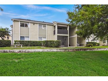 Back exterior view of condo building showcasing landscaping and lawn at 912 Lake Destiny Rd # G, Altamonte Springs, FL 32714