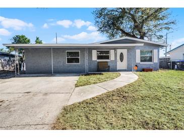 Gray house with a white door, small lawn, and walkway at 1527 Hernandes Dr, Orlando, FL 32808