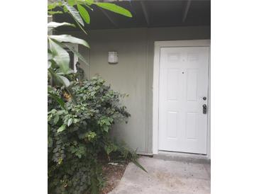 Exterior view of a house with green walls and a white door at 257 Scottsdale Sq # 257, Winter Park, FL 32792