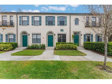 Three-unit townhouse building with green doors and landscaping at 711 Centervale Dr # 711, Celebration, FL 34747