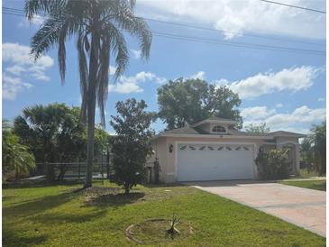 Charming single-story home featuring a two-car garage, complemented by lush landscaping and a vibrant green lawn at 770 Mink Ct, Poinciana, FL 34759