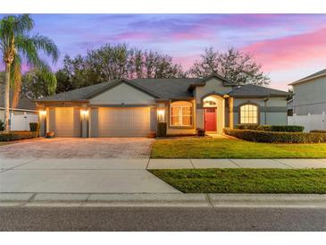 Two-story house with a three-car garage and landscaped yard at 15336 Firelight Dr, Winter Garden, FL 34787