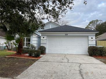 Newly painted house with a two-car garage and landscaped yard at 326 Morning Creek Cir, Apopka, FL 32712